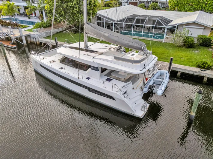  Yacht Photos Pics Modern Leopard 50 catamaran docked by waterfront property, 2021 model.