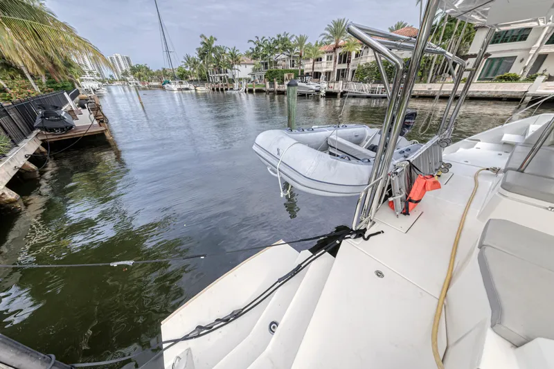  Yacht Photos Pics Leopard 50 yacht docked in a scenic canal, featuring a small inflatable boat.