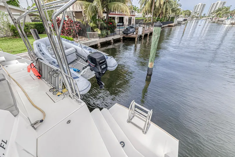  Yacht Photos Pics Luxury Leopard 50 yacht docked by waterfront homes, featuring a small motorboat.