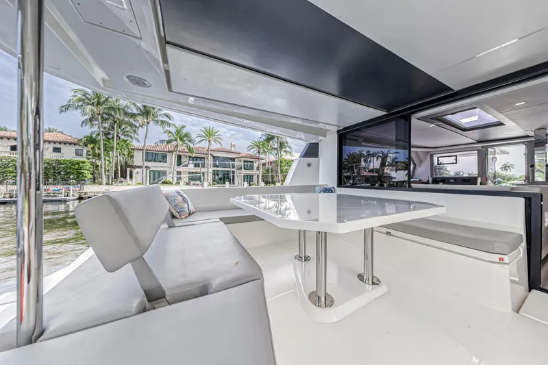  Yacht Photos Pics Luxurious Leopard 50 yacht interior with modern seating and table, showcasing waterfront views.