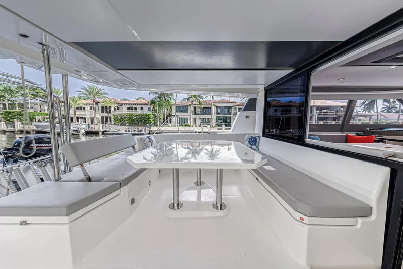  Yacht Photos Pics Modern Leopard 50 yacht deck with seating, table, and waterfront view, 2021 model.