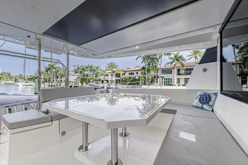  Yacht Photos Pics Luxurious Leopard 50 yacht deck with sleek table, modern seating, and waterfront view.