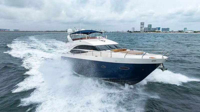  Yacht Photos Pics 2012 Princess 72 Motor Yacht cruising on open water, city skyline in background.