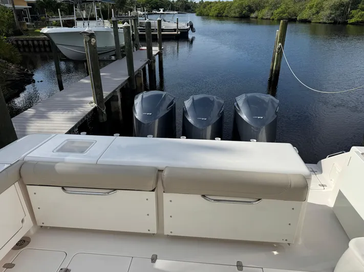  Yacht Photos Pics 2015 Pursuit OS 385 Offshore boat with triple V8 engines docked by a serene waterfront.