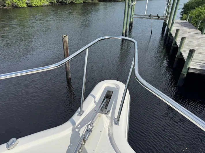  Yacht Photos Pics Bow view of 2015 Pursuit OS 385 Offshore boat near a wooden dock.