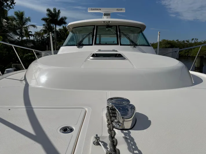  Yacht Photos Pics 2015 Pursuit OS 385 Offshore boat deck with anchor chain, palm trees in background.