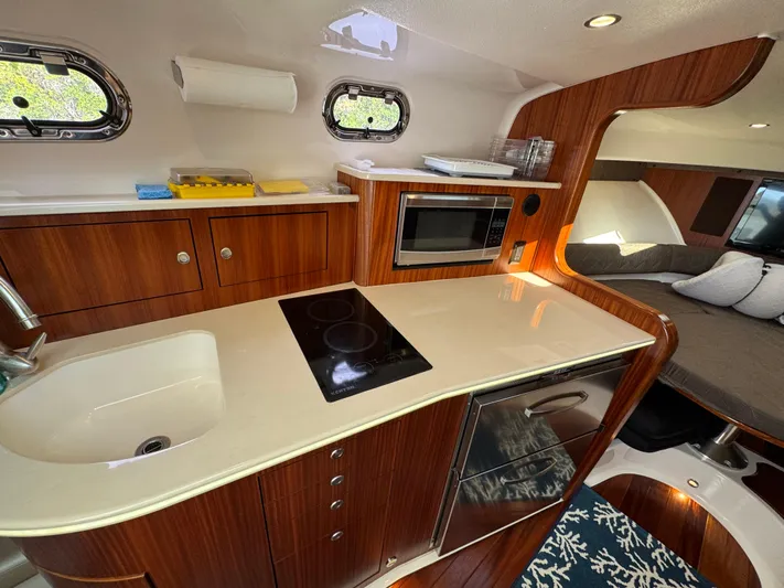  Yacht Photos Pics 2015 Pursuit OS 385 Offshore yacht interior with modern kitchen and cozy sleeping area.
