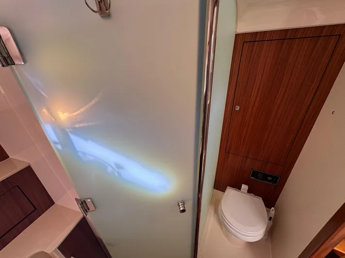  Yacht Photos Pics 2015 Pursuit OS 385 Offshore yacht bathroom with wooden paneling and modern fixtures.