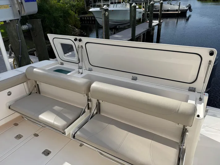  Yacht Photos Pics 2015 Pursuit OS 385 Offshore boat with foldable seating and storage, docked by the water.