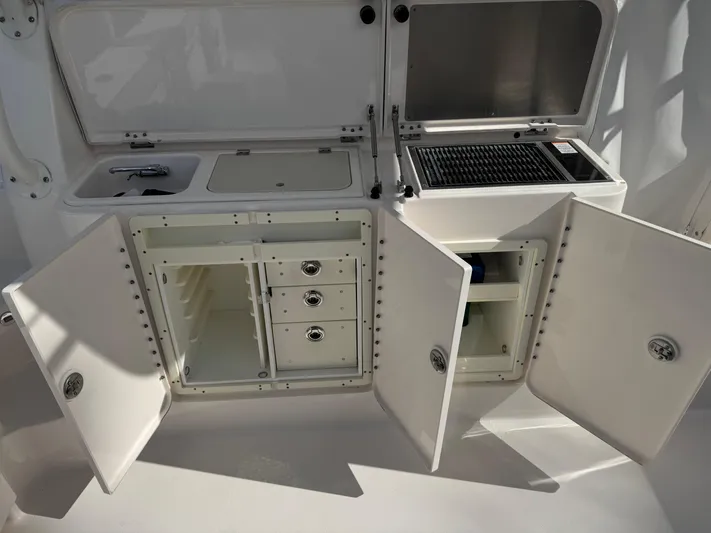  Yacht Photos Pics 2015 Pursuit OS 385 Offshore boat kitchen with storage cabinets and grill.