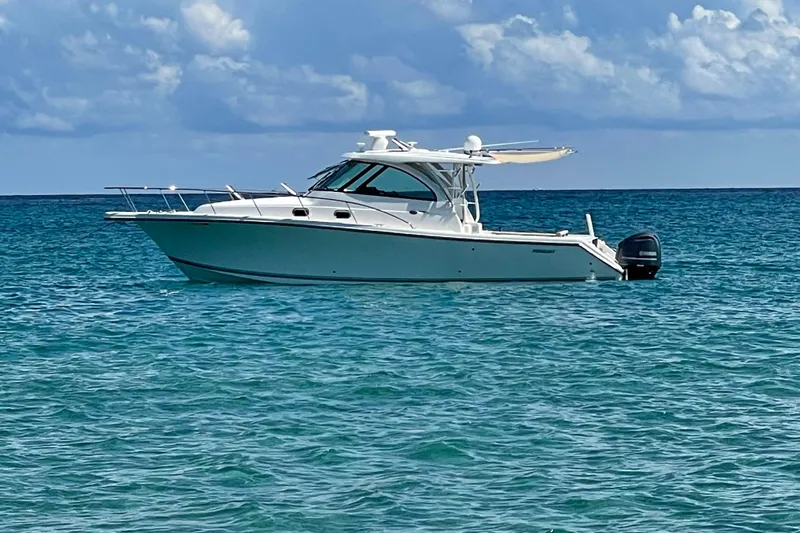  Yacht Photos Pics 2015 Pursuit OS 385 Offshore boat on calm ocean waters under a cloudy sky.