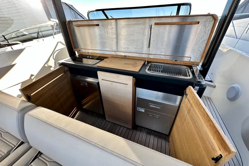  Yacht Photos Pics 2022 Cranchi A46 Luxury Tender kitchen area with sink, storage, and wooden cabinetry.