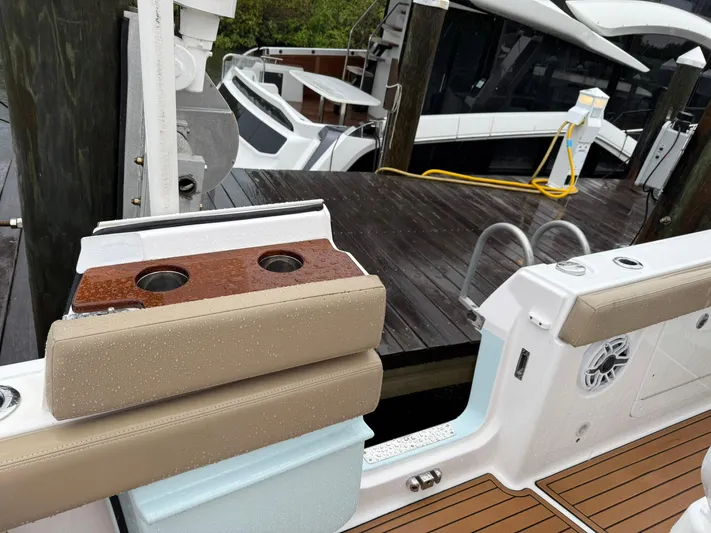  Yacht Photos Pics 2023 Everglades 285 Center Console boat docked, featuring cushioned seating and cup holders.