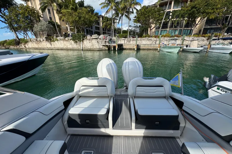  Yacht Photos Pics 2024 Regal LX9 boat with luxurious seating, docked in a scenic marina.