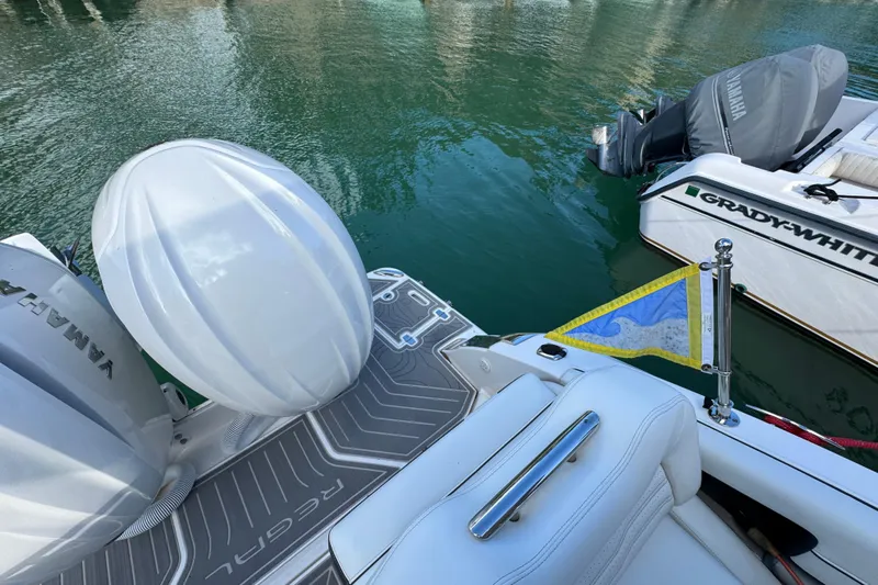  Yacht Photos Pics 2024 Regal LX9 boat with Yamaha engine, docked beside Grady-White, on calm water.