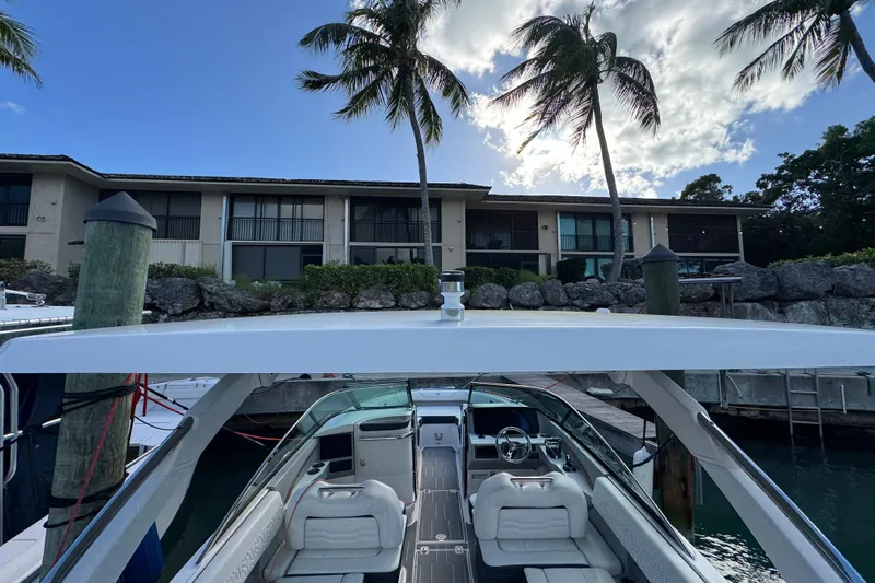  Yacht Photos Pics 2024 Regal LX9 boat docked near waterfront property with palm trees.