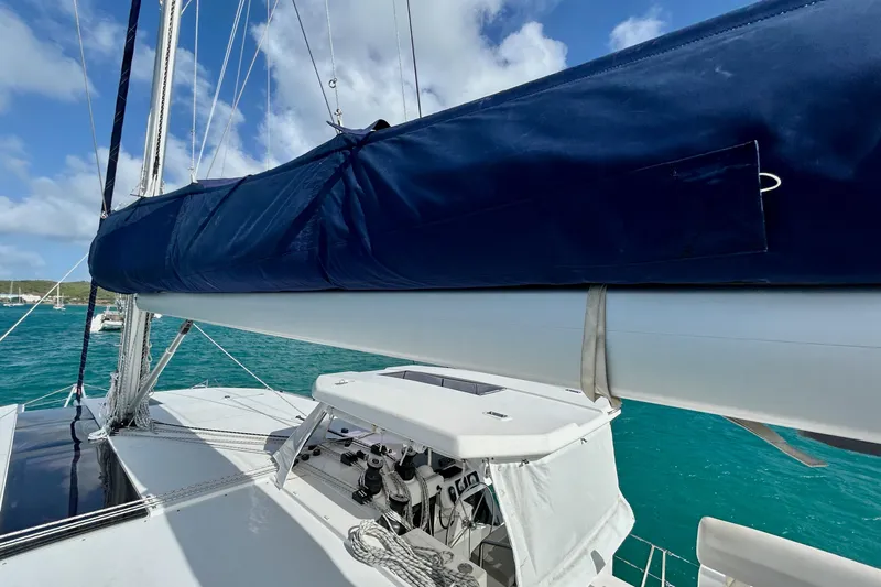  Yacht Photos Pics 2020 Leopard 50 catamaran with blue sail cover, anchored in turquoise waters.