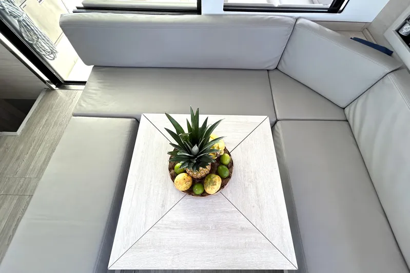  Yacht Photos Pics Modern yacht interior with gray seating, wooden table, and fruit centerpiece. Leopard 50, 2020 model.