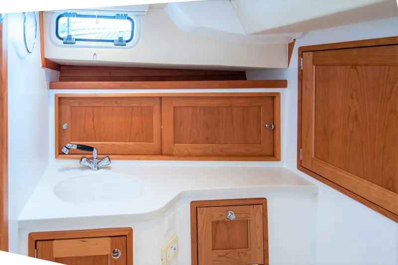 Sandora Yacht Photos Pics 2023 MJM 35 yacht interior with wooden cabinets and sink in compact bathroom.