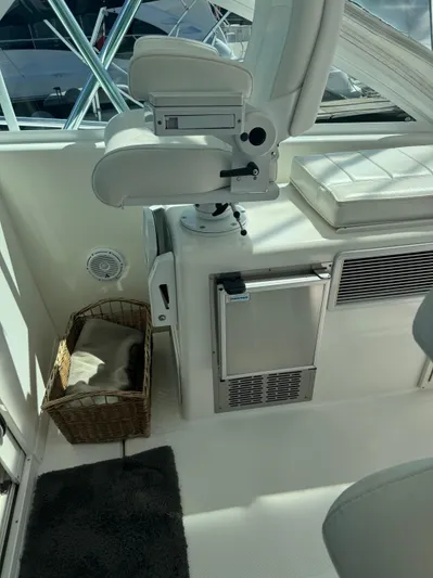 Cayuco Yacht Photos Pics 2010 Cabo 40 Express interior with captain's chair, storage basket, and mini fridge.
