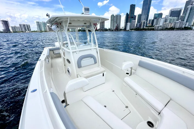 Why Knot Yacht Photos Pics 2014 Sailfish 320 CC boat on water with city skyline in background.