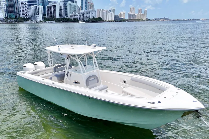 Why Knot Yacht Photos Pics 2014 Sailfish 320 CC boat on water with city skyline in background.