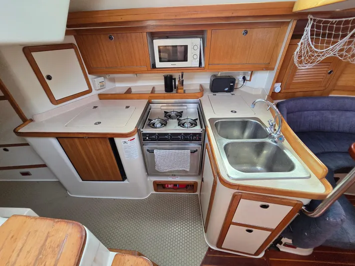 Yacht Photos Pics Galley kitchen in 2000 Catalina 42 MkII sailboat with stove, sink, and microwave.