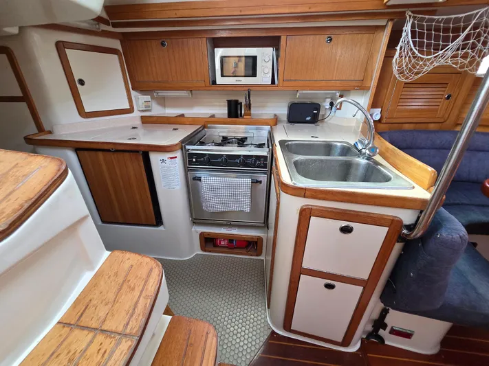  Yacht Photos Pics 2000 Catalina 42 MkII yacht kitchen with stove, sink, and wooden cabinetry.