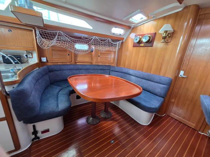  Yacht Photos Pics Interior of 2000 Catalina 42 MkII sailboat with wooden table and blue cushioned seating.