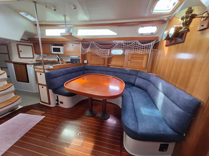  Yacht Photos Pics Interior of 2000 Catalina 42 MkII sailboat with wooden flooring and blue cushioned seating.