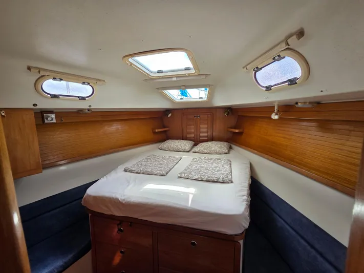  Yacht Photos Pics Cozy cabin interior of 2000 Catalina 42 MkII sailboat with double bed and wooden accents.