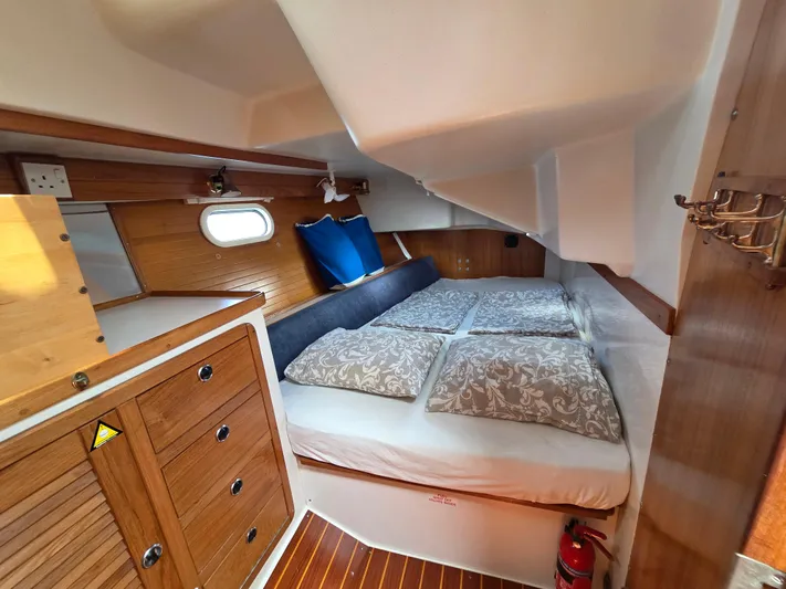  Yacht Photos Pics Cozy cabin interior of 2000 Catalina 42 MkII sailboat with wooden cabinetry and bedding.