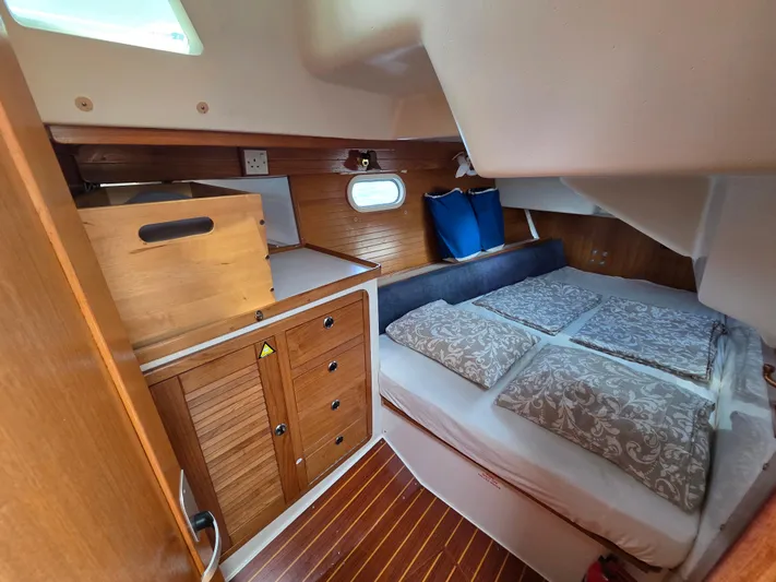  Yacht Photos Pics Cozy cabin interior of 2000 Catalina 42 MkII sailboat with wooden cabinetry and bedding.