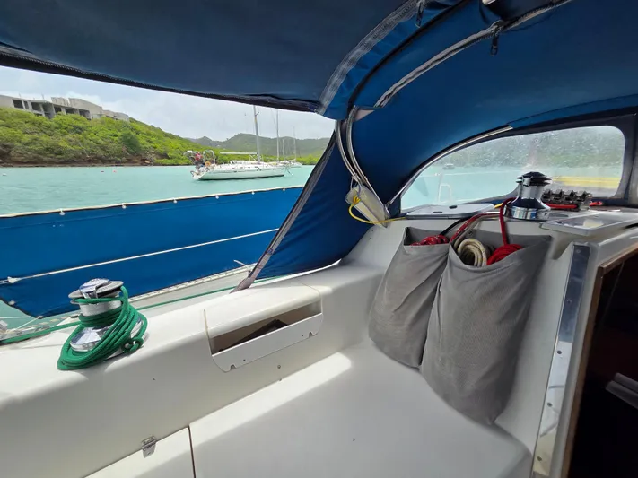  Yacht Photos Pics Interior view of a 2000 Catalina 42 MkII sailboat with blue canopy and scenic water backdrop.
