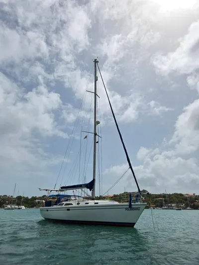  Yacht Photos Pics Catalina 42 MkII sailboat from 2000 on calm waters under a cloudy sky.