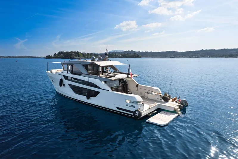 M8-15 Yacht Photos Pics 2023 Bluegame BGX 63 yacht on serene blue waters under a clear sky.