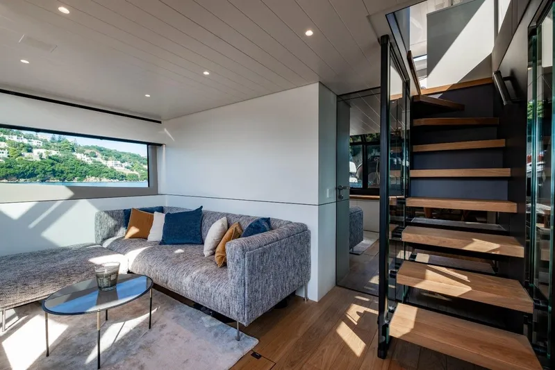 M8-15 Yacht Photos Pics Luxurious interior of 2023 Bluegame BGX 63 yacht with modern seating and wooden staircase.