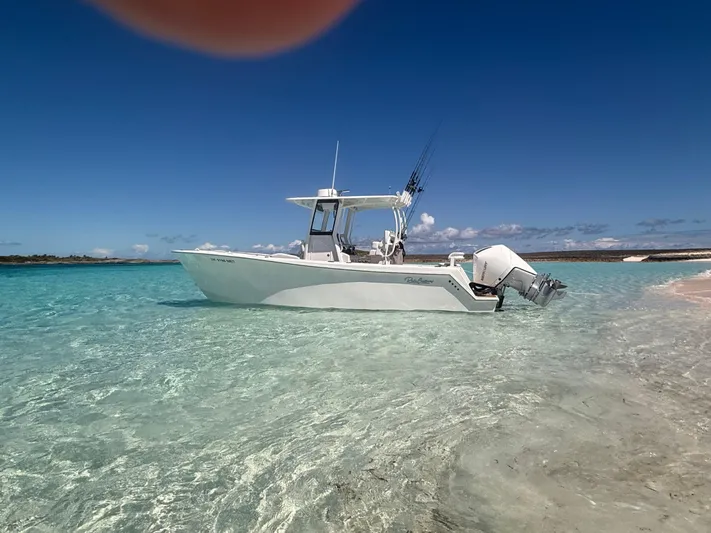  Yacht Photos Pics 2025 Pair Customs 28 Center Console boat in clear turquoise water near sandy beach.