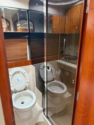  Yacht Photos Pics Bathroom interior of 2009 Cruisers Yachts 390 Sports Coupe with mirrored cabinets and toilet.