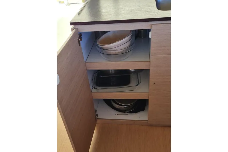 Yacht Photos Pics Open kitchen cabinet with stacked cookware and baking dishes, Bali 4.5 model, 2016.