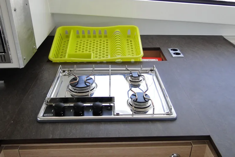  Yacht Photos Pics Compact kitchen with a two-burner stove and yellow dish rack on a Bali 4.5, 2016 model.