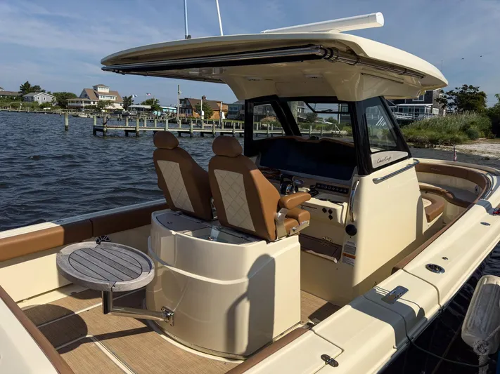 Rest Assured Yacht Photos Pics 2019 Chris-Craft 30 Catalina boat interior with seating and table, docked by the water.