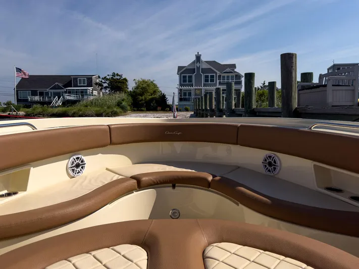 Rest Assured Yacht Photos Pics 2019 Chris-Craft 30 Catalina boat interior with brown leather seating, docked near waterfront homes.