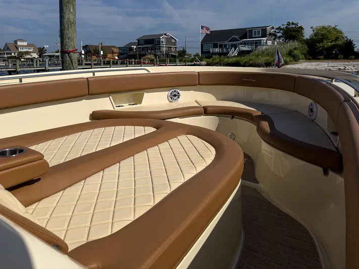 Rest Assured Yacht Photos Pics 2019 Chris-Craft 30 Catalina boat interior with tan leather seating and coastal background.
