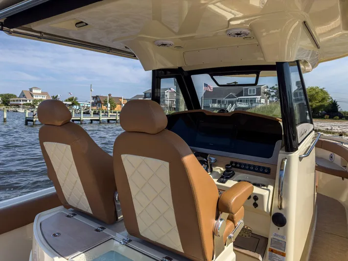 Rest Assured Yacht Photos Pics Interior of 2019 Chris-Craft 30 Catalina boat with leather seats and dashboard view.