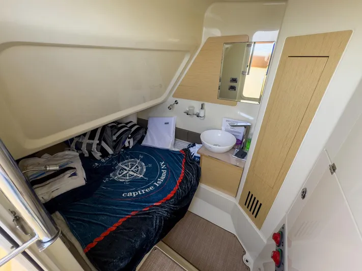 Rest Assured Yacht Photos Pics 2019 Chris-Craft 30 Catalina cabin interior with bed, sink, and storage.