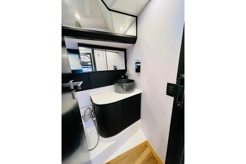 Gustavia I Yacht Photos Pics Modern bathroom interior on 2021 OKEAN 55 yacht, featuring sleek black and white design.