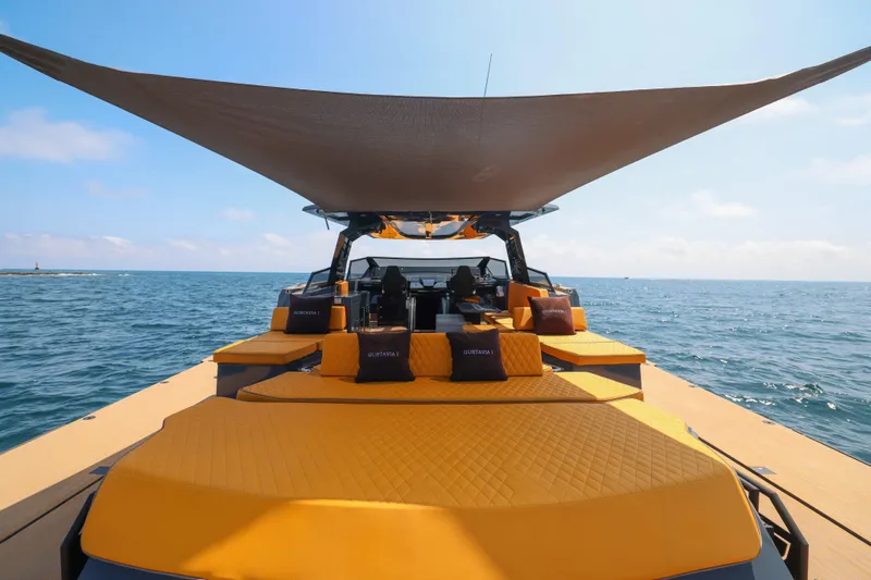 Gustavia I Yacht Photos Pics Luxurious 2021 OKEAN 55 yacht with sunshade and vibrant seating on open sea.