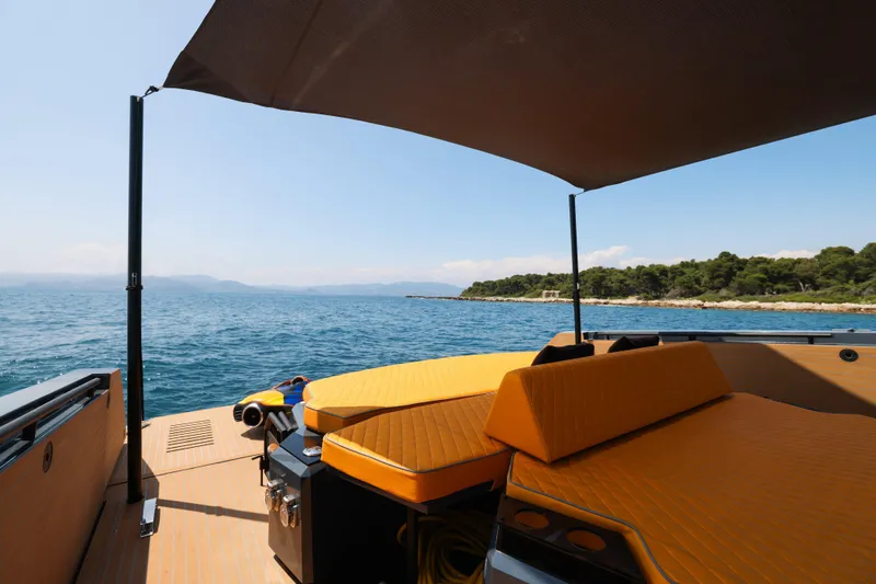 Gustavia I Yacht Photos Pics Luxury OKEAN 55 yacht deck with sunshade, overlooking serene ocean and coastline, 2021 model.