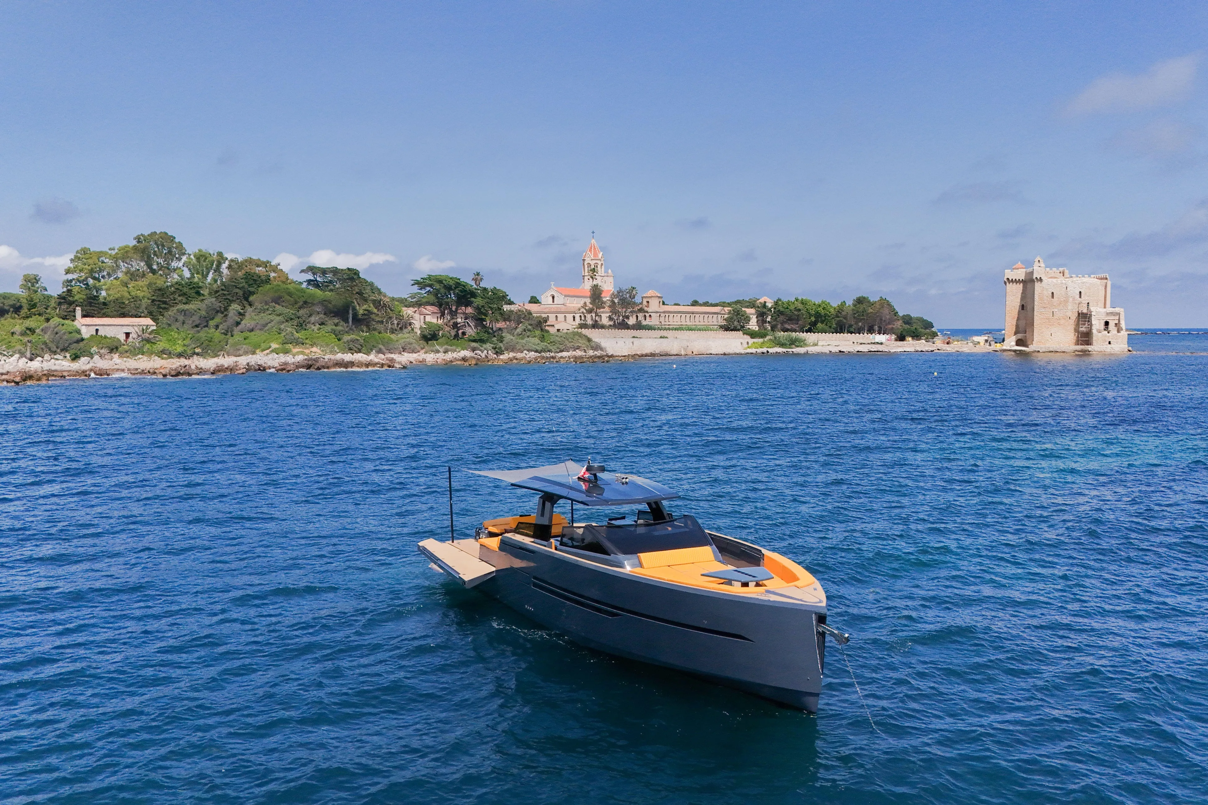 Gustavia I Yacht Photos Pics Luxury 2021 OKEAN 55 yacht cruising near historic coastal architecture.